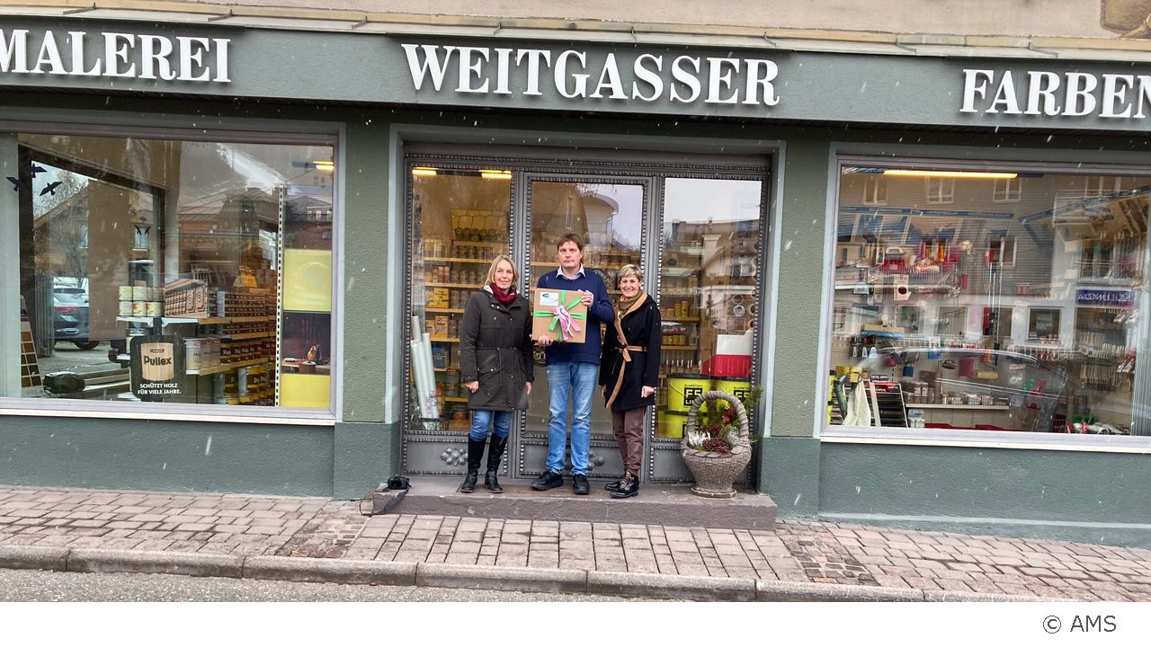 Foto: Im Zuge der Kampagne „AMS Newsletter für Unternehmen“ des AMS Steiermark überreichten Abteilungsleiterin Gertraud Koller und SfU-Beraterin Brigitte Zechmann des AMS Liezen nun Thomas Weitgasser vom Unternehmen Malerei Farben Weitgasser in Schladming ein mit steirischen Schmankerln gut gefülltes Geschenkspaket.