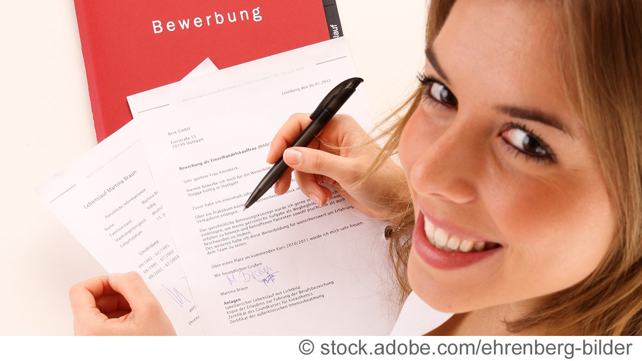 Junge Frau mit Bewerbungsmappe und Unterlagen und Stift in der Hand