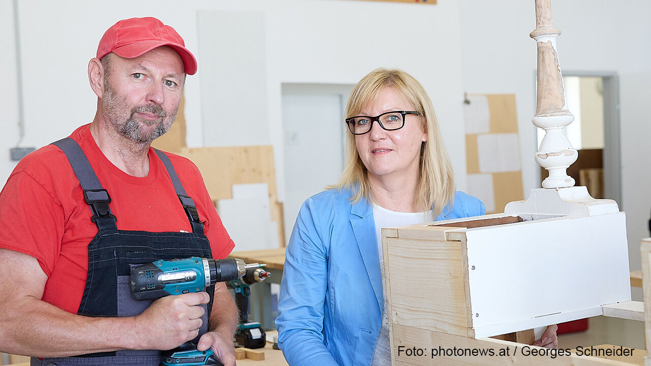 Foto der AMS NÖ-Landesgeschäftsführerin Sandra Kern im Gespräch mit Jobwerk-Teilnehmer Helmut Belanyecz in der Hozwerkstatt