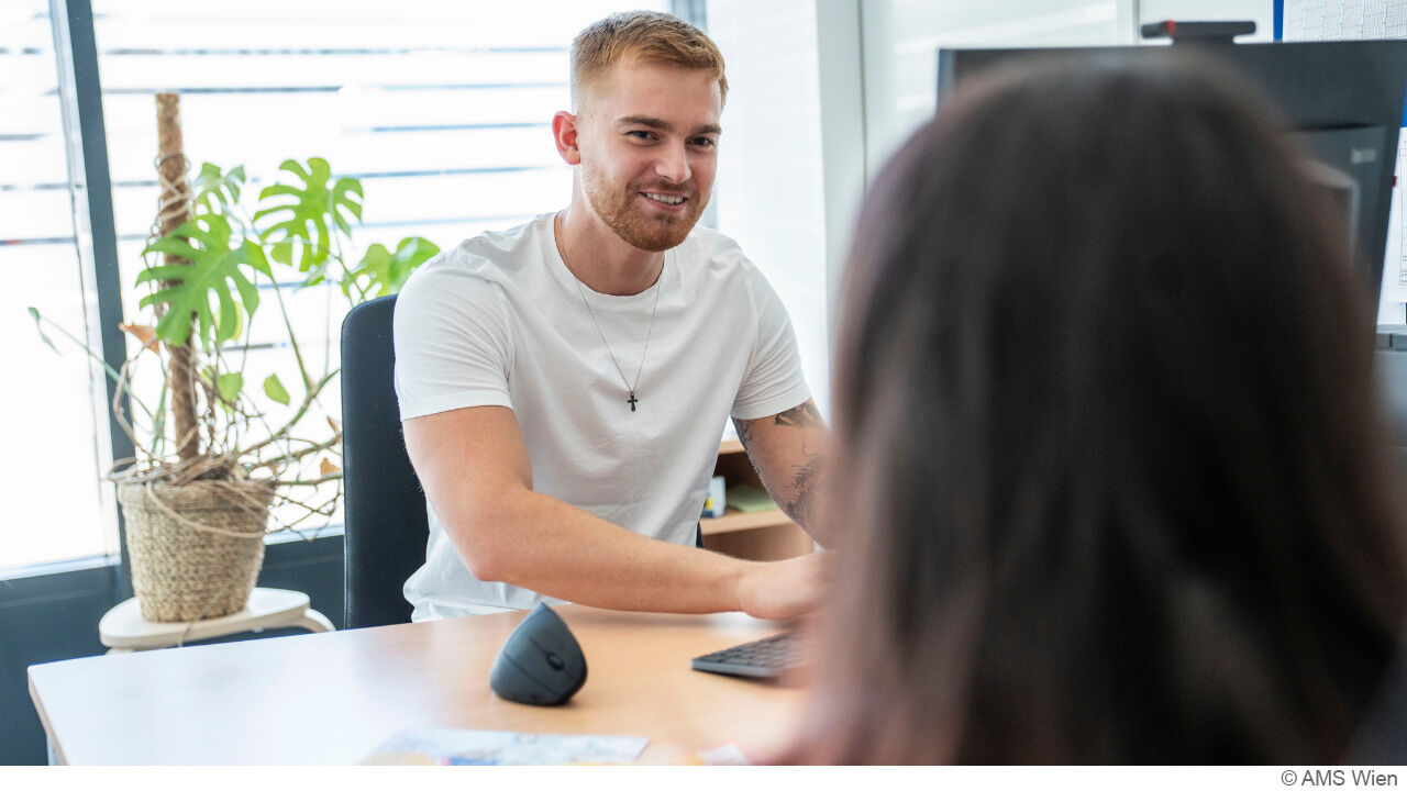 junger Mann sitz vor dem PC und führt ein Beratungsgespräch
