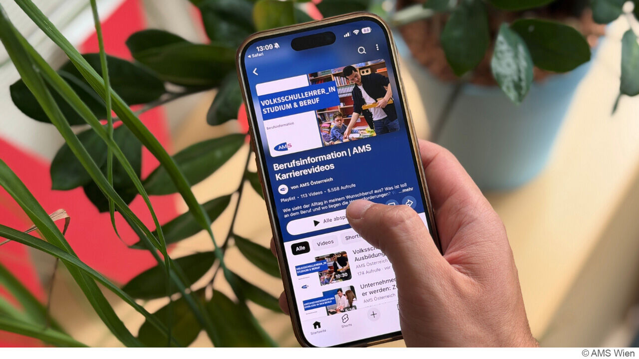 Handy mit Informationen des Arbeitsmarktservice auf blauem Hintergrund