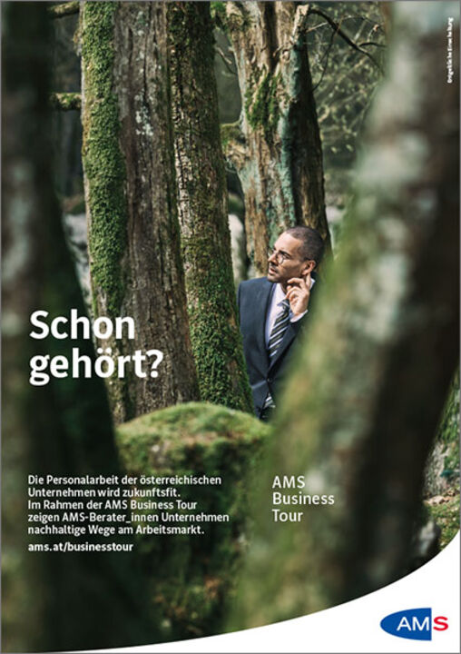 Ein Mann steht im Business-Outfit im Wald zwischen Bäumen und nimmt Geräusche wahr. Text: "Schon gehört? Die Personalarbeit der österreichischen Unternehmen wird zukunftsfit. Im Rahmen der AMS Business Tour zeigen AMS-Berater_innen Unternehmen nachhaltige Wege am Arbeitsmarkt. ams.at/businesstour"