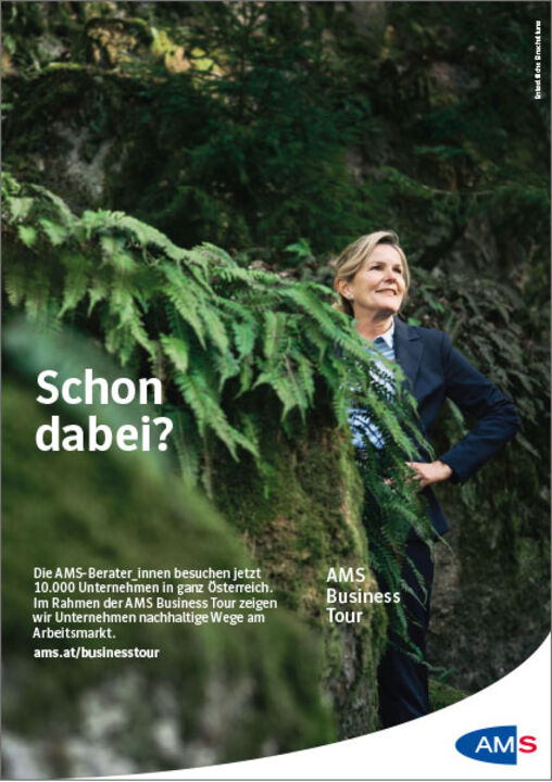 Eine Frau steht im Business-Outfit im Wald zwischen mit Moos und Farnen bedeckten Felsen und schaut selbstsicher in die Weite. Text: "Schon dabei? Die AMS-Berater_innen besuchen jetzt 10000 Unternehmen in ganz Österreich. Im Rahmen der AMS Business Tour zeigen wir Unternehmen nachhaltige Wege am Arbeitsmarkt. ams.at/businesstour"