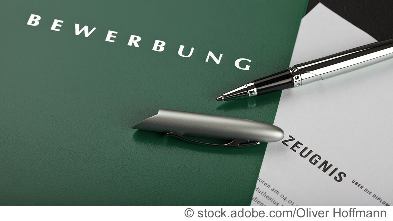 kugelschreiber auf grüner bewerbungsmappe mit zeugnis